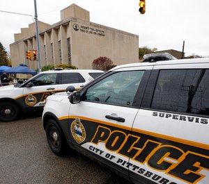 Pittsburgh Police vehicles close the street adjacent to the Tree of Life Synagogue on Saturday, Nov. 3, 2018, before a Shabbat morning service is held on the street corner in the Squirrel Hill neighborhood of Pittsburgh. (AP Photo/Gene J. Puskar)