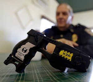 In this Nov. 14, 2013, file photo, a Taser X26 sits on a table in Knightstown, Ind. (AP Photo/Michael Conroy, File)