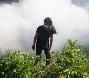A protester walks in Philadelphia near smoke after tear gas was dispersed during a march calling for justice over the death of George Floyd. (AP Photo/Matt Rourke)