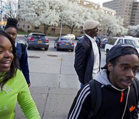 In a photograph taken Wednesday, April 23, 2014, Dr. Kai Smith, background center right, former gang member and now founder and Executive Director of GRAAFICS, laughs as he walks with GRAAFICS students.