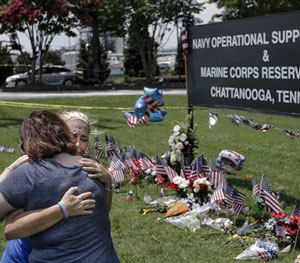 Two embrace in front of a makeshift memorial at the Navy Operational Support Center and Marine Corps Reserve Center, Saturday, July 18, 2015, for the victims of the July 16 shootings in Chattanooga, Tenn.