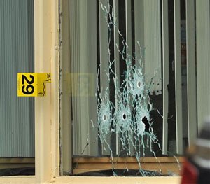 Bullet holes show in a window of a Days Inn Hotel office from a shooting early Thursday morning, July 7, 2016.