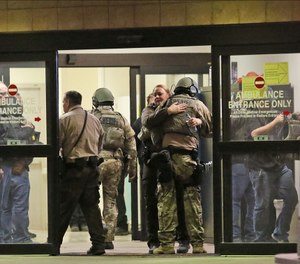 Ector County Sheriff deputies hug in the ambulance entrance at Medical Center Hospital after three sheriff's deputies were shot in the line of duty, according to the Odessa American, late Monday, Jan. 14, 2019, in North Odessa, Texas. (Jacob Ford/Odessa American via AP)