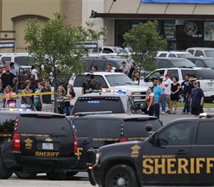 People at the Central Texas MarketPlace watch a crime scene near the parking lot of a Twin Peaks restaurant Sunday, May 17, 2015.
