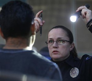 DWI police officer Stacie Brown does a Horizontal Gaze Nystagmus test on a man arrest for a DWI on Wednesday, Dec. 14, 2016 at the Arlington Police Department in Arlington, Texas. (Rose Baca/Dallas Morning News/TNS)