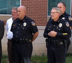 In this frame from video, McKinney law enforcement officials including Police Chief Greg Conley, front right, listen to Mayor Brian Loughmiller during a news conference. (AP Image)