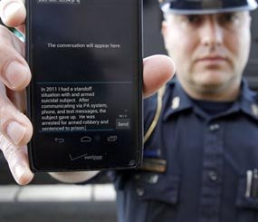 In a May 6, 2014 photo, Sgt. Andres Wells of the Kalamazoo Deptartment of Public Safety, who successfully used text messaging to negotiate with a suicidal robbery suspect during a 2011 standoff, shows his phone.