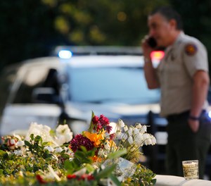 A bouquet of flowers, left by mourners, lays near the site of Wednesday's mass shooting, in Thousand Oaks, Calif., Friday, Nov. 9, 2018.