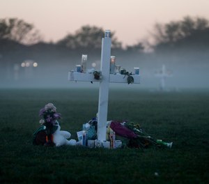In this Feb. 17, 2018, file photo, an early morning fog rises where 17 memorial crosses were placed, for the 17 deceased students and faculty from the shooting at Marjory Stoneman Douglas High School in Parkland, Fla.