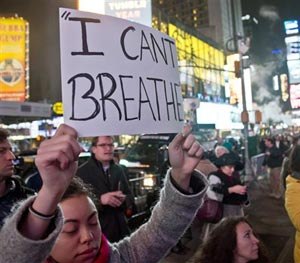 Protesters in Times Square carry signs in reaction to a non indictment against a police officer in the death of Eric Garner, Wednesday Dec. 3, 2014 in New York.