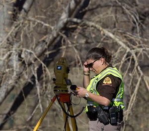 In this March 7, 2015 photo, officials respond to a report of car in the Spanish Fork River in Spanish Fork, Utah.