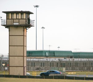 In this Feb. 1, 2017, file photo, a prison guard stands on a tower during a hostage situation at James T. Vaughn Correctional Center in Smyrna, Del. Jurors are hearing closing arguments Thursday, Nov. 15, 2018, in the trial of three Delaware inmates charged in a prison riot in which a guard was killed and three other staffers taken hostage. (Suchat Pederson/The News Journal via AP, File)