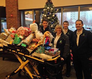Ada County Paramedics stand with a toy-filled gurney for children hospitalized over the holidays.