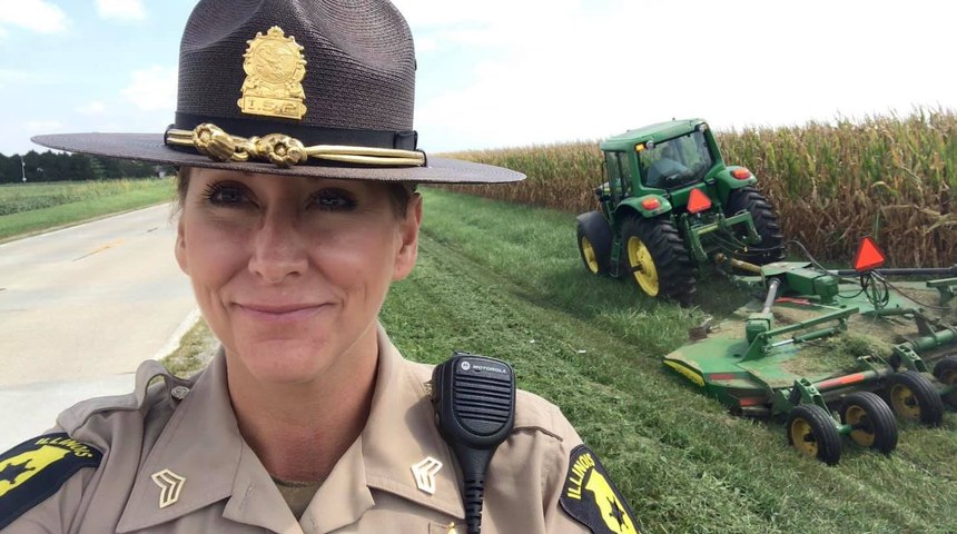 Illinois State Police Sgt. Tracy Lillard takes a selfie as her father mows along the roadside in rural Champaign-Urbana, to point out that drivers need to practice caution around tractors and slow-moving vehicles.