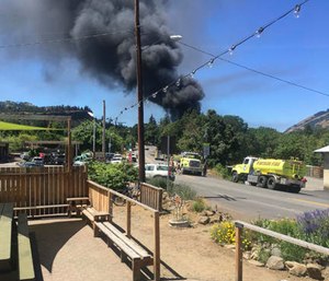 A train towing cars full of oil sends up a plume of smoke after derailing Friday near Mosier, Ore. (Silas Bleakley via AP)