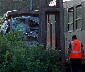 An employee of the railways works as the scene after two trains collided in Deguin, near Pau, southwestern France, Thursday, July 17, 2014. (AP Photo/Bob Edme)