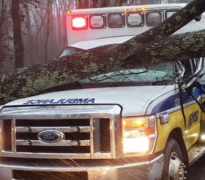 Three Hunstville Emergency Medical Services Inc. (HEMSI) paramedics sustained minor injuries after a tree fell onto their ambulance, striking the windshield. (Photo/HEMSI)
