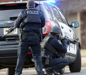 In this Tuesday, March 24, 2015 photo, officers work the scene where a Wisconsin State Patrol trooper died in a shootout. (AP Image)