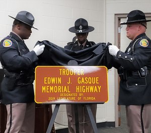 A Florida Highway Patrol honor guard unveils a sign memorializing Trooper Edwin J. Gasque, shot and killed on Oct. 26, 1961, when he was ambushed. (Photo/TNS)