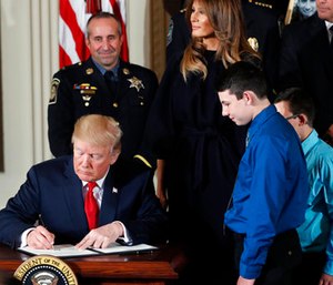 President Donald Trump signs a presidential memorandum declaring the opioid crisis a public health emergency in the East Room of the White House.