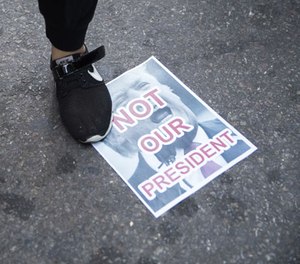 Protestors stands on a poster during a demonstration against the election of President-elect Donald Trump during a rally outside Trump Tower, Saturday, Nov. 12, 2016, in New York.