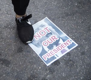 Protestors stands on a poster during a demonstration against the election of President-elect Donald Trump during a rally outside Trump Tower, Saturday, Nov. 12, 2016, in New York.