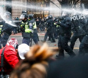 In this Jan. 20, 2017, file photo, police fire pepper spray at protestors during a demonstration in downtown after the inauguration of President Donald Trump.