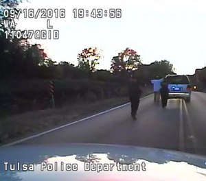 In this image made from a Friday, Sept. 16, 2016 police video, Terence Crutcher, center, is pursued by police officers as he walk to an SUV in Tulsa, Okla.