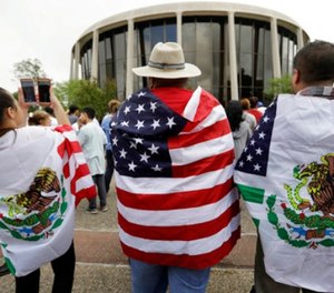 In this June 26, 2017, file photo, protesters outside the federal courthouse in San Antonio, Texas, take part in a rally to oppose a new Texas