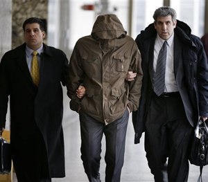 In this Feb. 27, 2014, file photo, Wojciech Braszczok, center, is led into the courtroom while covering his face in New York. (AP Image)