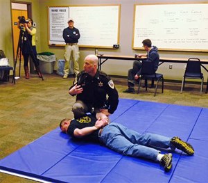 Dane County Sheriff's Deputy Eric Markgraf demonstrates the steps police are taught to take after shooting someone, during a media training session in Waunakee, Wis.