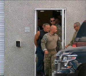 This frame grab from video provided by WPLG-TV shows FBI agents escorting Cesar Sayoc, in sleeveless shirt, in Miramar, Fla., on Friday, Oct. 26, 2018. (WPLG-TV via AP)