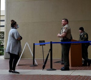 Jennifer Morrison, of Simi Valley, speaks with a Ventura County Sheriff's deputy at the entrance of Ventura County Superior Court on Friday. County law enforcement has asked the state to change bail rules due to high crime rates.