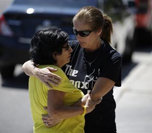 Julie Ramos, right, embraces neighbor Ana Kuhry outside of Ramos' home Wednesday, July 30, 2014, in Las Vegas.
