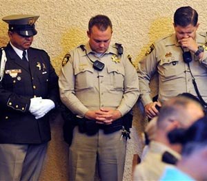 Las Vegas police bow their heads during a memorial service for Joseph Wilcox at Palm Downtown Mortuary on Sunday, June 22, 2014, in Las Vegas.