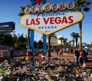 Flowers, candles and other items surround the famous Las Vegas sign at a makeshift memorial for victims of a mass shooting Monday, Oct. 9, 2017, in Las Vegas.