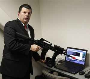 Bob Walker, of Cole Engineering Services, Inc., displays an AR-15 that will be used by police in a virtual first-person computer training program.