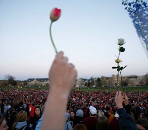 In this Tuesday, April 17, 2007 file photo, People gather for a vigil on the drill field following the shootings on the Virginia Tech campus in Blacksburg, Va. (AP Photo/Casey Templeton, File)