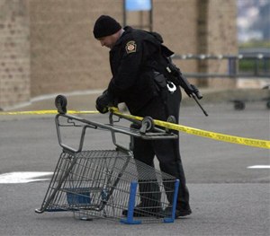 State Trooper sets up a police line using a shopping cart following reports of shots fired near a Wal-Mart store in Wilkes-Barre, Pa., Saturday, Oct. 17, 2015.