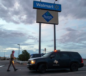 In this Aug. 4, 2019, file photo a Texas State Trooper walks back to his car while providing security outside the Walmart store in the aftermath of a mass shooting in El Paso, Texas. (AP Photo/Andres Leighton, File)