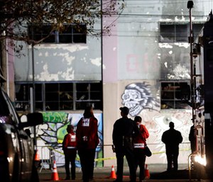 Emergency crews stand in front of the site of a warehouse fire in Oakland, Calif.