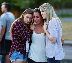People mourn at a memorial in the parking lot of Kamiak High School Sunday, July 31, 2016.