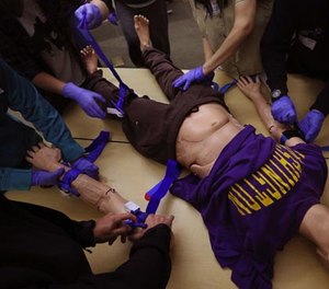 With the help of Hans the manikin, students in the Stop the Bleed program learn how to apply tourniquets at Harborview Medical Center.