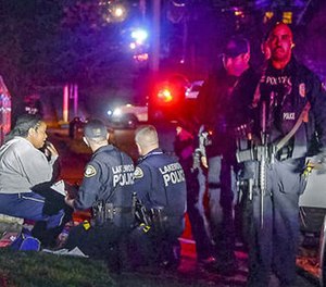 Police stand by a distraught Kristi Croskey at the scene where a Tacoma Police officer was shot while responding to a domestic call in East Tacoma, Wash., Wednesday, Nov. 30, 2016.