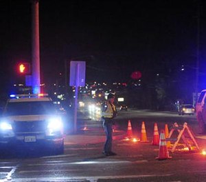 A Washington State Trooper directs traffic around a roadblock near Skagit Valley College in Mount Vernon, Wash., Thursday, Dec. 15, 2015.