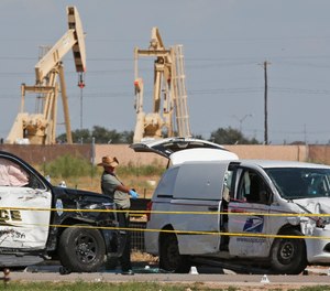 In this Sunday, Sept. 1, 2019, file photo, law enforcement officials process the crime scene from Saturday's shooting which ended with the shooter, Seth Ator, being shot dead by police in a stolen mail van, right, in Odessa, Texas.