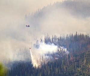 A helicopter dumps a load of water onto one of the fires burning on a ridge west of Leavenworth, Wash. (AP Photo/The Seattle Times, Mike Siegel)