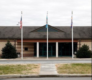 This Dec. 22, 2017, file photo shows the front entrance of the James T. Vaughn Correctional Center in Smyrna, Del. Delaware taxpayers have shelled out more than $360,000 in legal defense costs for 18 prisoners charged in a deadly prison riot last year - and the bills will continue to pile up as the trials get under way. (AP Photo/Patrick Semansky, File)