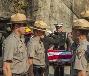 In this Oct. 8, 2014, file photo, Yosemite National Park Rangers transfer the body of a Cal Fire pilot who was killed in an airplane crash in Yosemite National Park, Calif. An investigation into the 2014 fatal crash found that the pilot was warned to avoid a hazardous tree to the right of his flight path before a wing struck trees to the left. (AP Photo/Al Golub, File)