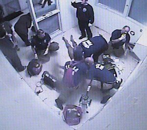 In this surveillance photo, emergency personnel respond to Elliot Williams, whose death after lying naked in a Tulsa County jail cell for five days with a broken neck, was the cause of a $10M lawsuit. (Photo/AP).